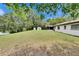 Expansive backyard with lush lawn, lake view, sheds, and a screened porch at 16112 N 15Th St, Lutz, FL 33549
