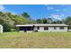 Exterior showcasing a screened porch, lush lawn, and a storage shed at 16112 N 15Th St, Lutz, FL 33549
