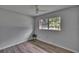 Cozy bedroom with wood-look flooring, ceiling fan, and a bright window offering natural light at 16112 N 15Th St, Lutz, FL 33549