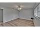 Well-lit bedroom with wood-look flooring, a ceiling fan, large window with blinds, and a closet nearby at 16112 N 15Th St, Lutz, FL 33549