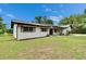 Charming one story home with white painted brick, brown shutters, well maintained landscaping, and a large yard at 16112 N 15Th St, Lutz, FL 33549