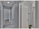 Bright hallway with neutral walls and tile flooring, leading to bedrooms and a bathroom at 16112 N 15Th St, Lutz, FL 33549
