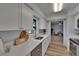 Modern kitchen featuring white countertops, stainless steel appliances, and a view into a living room at 16112 N 15Th St, Lutz, FL 33549