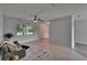 Spacious living room with neutral decor, tile flooring, ceiling fan and large window overlooking the front yard at 16112 N 15Th St, Lutz, FL 33549
