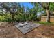 Expansive backyard offering a relaxed outdoor space with deck, seating, privacy fence, and lush trees at 1753 San Mateo Dr, Dunedin, FL 34698