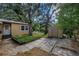 Backyard featuring a storage shed, mature trees, and an outdoor seating area at 1753 San Mateo Dr, Dunedin, FL 34698