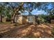 Large backyard featuring a covered patio area and plenty of shaded space with mature trees at 1753 San Mateo Dr, Dunedin, FL 34698