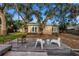 Expansive backyard with a weathered wooden deck, seating, and a canopy of mature trees at 1753 San Mateo Dr, Dunedin, FL 34698