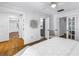 Spacious bedroom featuring all-white walls and bedding with wood flooring and an ensuite bathroom at 1753 San Mateo Dr, Dunedin, FL 34698