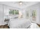 Bright bedroom features a ceiling fan, wood floors, and white french doors leading outside at 1753 San Mateo Dr, Dunedin, FL 34698