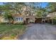 Charming single-story home features a large driveway, carport, mature landscaping, and mature shade trees at 1753 San Mateo Dr, Dunedin, FL 34698