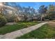Charming home with a cozy cottage feel, featuring a well-manicured lawn and lush, mature trees at 1753 San Mateo Dr, Dunedin, FL 34698