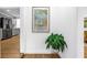 Hallway leading to kitchen featuring wood floors, modern decor, and stainless steel appliances at 1753 San Mateo Dr, Dunedin, FL 34698