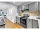 A modern kitchen with grey cabinets, stainless steel appliances, and white countertops provides a great cooking space at 1753 San Mateo Dr, Dunedin, FL 34698