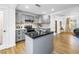 Renovated kitchen with gray cabinets, subway tile backsplash, stainless appliances, and an island with granite countertop at 1753 San Mateo Dr, Dunedin, FL 34698