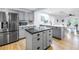 Open concept kitchen with central island, stainless steel fridge, tile backsplash and lots of light at 1753 San Mateo Dr, Dunedin, FL 34698
