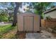 Storage shed with a green trim in a verdant backyard surrounded by mature trees at 1753 San Mateo Dr, Dunedin, FL 34698