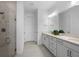 Neutral bathroom featuring a walk-in shower with glass door, white cabinets and tile floors at 17881 Star Ruby Pl, Nokomis, FL 34275