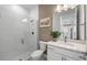 Well-lit bathroom with white subway tile in the walk-in shower and white vanity at 17881 Star Ruby Pl, Nokomis, FL 34275