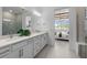 Bathroom with dual sinks, white cabinets, light countertops and view of bedroom at 17881 Star Ruby Pl, Nokomis, FL 34275