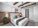 Beautifully staged bedroom with wood beam ceiling, neutral colors, and stylish chandelier at 17881 Star Ruby Pl, Nokomis, FL 34275