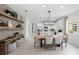 Bright, open dining area with modern chandelier, decorative shelves and views of the state-of-the-art kitchen at 17881 Star Ruby Pl, Nokomis, FL 34275