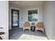 Welcoming front porch with stylish tile flooring, two chairs, and a view of the entryway at 17881 Star Ruby Pl, Nokomis, FL 34275