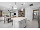 Open concept kitchen showcases island with quartz countertops, pendant lights, and seamless flow into the dining and living areas at 17881 Star Ruby Pl, Nokomis, FL 34275