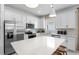 Bright kitchen with stainless steel appliances, quartz countertops, and white cabinetry at 17881 Star Ruby Pl, Nokomis, FL 34275