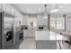 Modern kitchen featuring stainless steel appliances, a large island, and stylish white cabinets at 17881 Star Ruby Pl, Nokomis, FL 34275