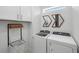 Bright laundry room with modern appliances and decorative wall art at 17881 Star Ruby Pl, Nokomis, FL 34275
