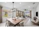 Open-concept living and dining area featuring modern light fixtures, lots of natural light, and stylish decor at 17881 Star Ruby Pl, Nokomis, FL 34275