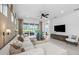 Well-lit living room with contemporary furnishings, a ceiling fan, access to the outdoor living space and scenic views at 17881 Star Ruby Pl, Nokomis, FL 34275