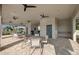 Covered outdoor lounge area featuring ceiling fans, comfortable seating, and a peaceful garden view at 17881 Star Ruby Pl, Nokomis, FL 34275