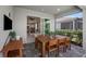 Covered outdoor patio featuring a natural wood table and view of the living room at 17881 Star Ruby Pl, Nokomis, FL 34275