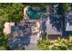 Aerial view of backyard pool area, home and roof, and mature trees at 1805 W Jetton Ave, Tampa, FL 33606