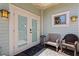 Charming back porch with a bench, wicker chair, accent table and double doors at 1805 W Jetton Ave, Tampa, FL 33606