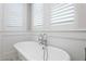 Classic white clawfoot bathtub with chrome fixtures beneath shuttered windows at 1805 W Jetton Ave, Tampa, FL 33606