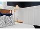 Close-up of a bedside table, accenting dark wallpaper, modern lighting, and pillows at 1805 W Jetton Ave, Tampa, FL 33606