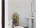 Powder room with a pedestal sink and wood storage shelves next to the toilet at 1805 W Jetton Ave, Tampa, FL 33606