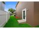 Sideyard features green grass and a door to the exterior of the home at 1880 Fuller Dr, Clearwater, FL 33755