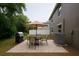 Backyard features patio with furniture, grill, shade umbrella, and exterior of the home at 1880 Fuller Dr, Clearwater, FL 33755