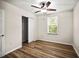 Bright bedroom with wood-look flooring, a ceiling fan, and a closet at 1880 Fuller Dr, Clearwater, FL 33755