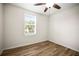 Bedroom features wood floors, a ceiling fan, natural light from the window and spacious layout at 1880 Fuller Dr, Clearwater, FL 33755