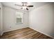 Bedroom featuring wood-look floors, a window, and a ceiling fan at 1880 Fuller Dr, Clearwater, FL 33755
