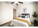 Cozy bedroom featuring a ceiling fan, stylish decor, and wood-look flooring at 1880 Fuller Dr, Clearwater, FL 33755