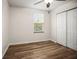 Bedroom with wood-look floors, a ceiling fan, window, and closet at 1880 Fuller Dr, Clearwater, FL 33755