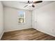 Bright bedroom with wood-look floors, a window, and ceiling fan at 1880 Fuller Dr, Clearwater, FL 33755