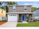 Charming two-story home with a bright blue front door and well-manicured landscaping at 1880 Fuller Dr, Clearwater, FL 33755