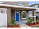 Inviting front porch with a bright blue door, manicured plants, and fresh mulch at 1880 Fuller Dr, Clearwater, FL 33755